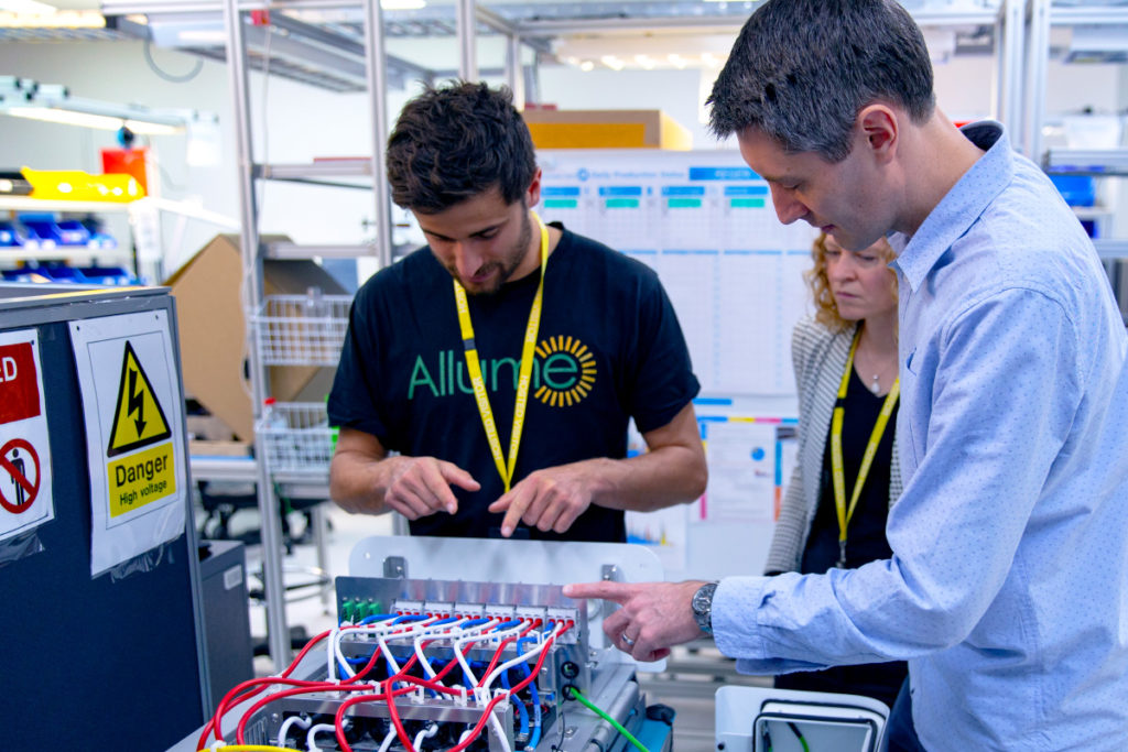 Allume CEO Cameron Knox, CTO Kristy Battista and PI's Andrew Hornby working on a SolShare unit